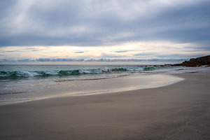 Stokes Bay Beach at sunset with waves and rocks, Australia