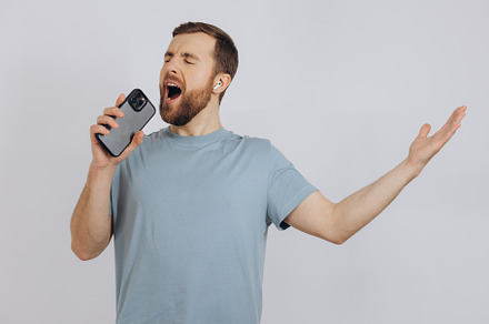 Happy bearded man dancing with earphones, listening music in hea, a Technology Photo by Cherkas Photography