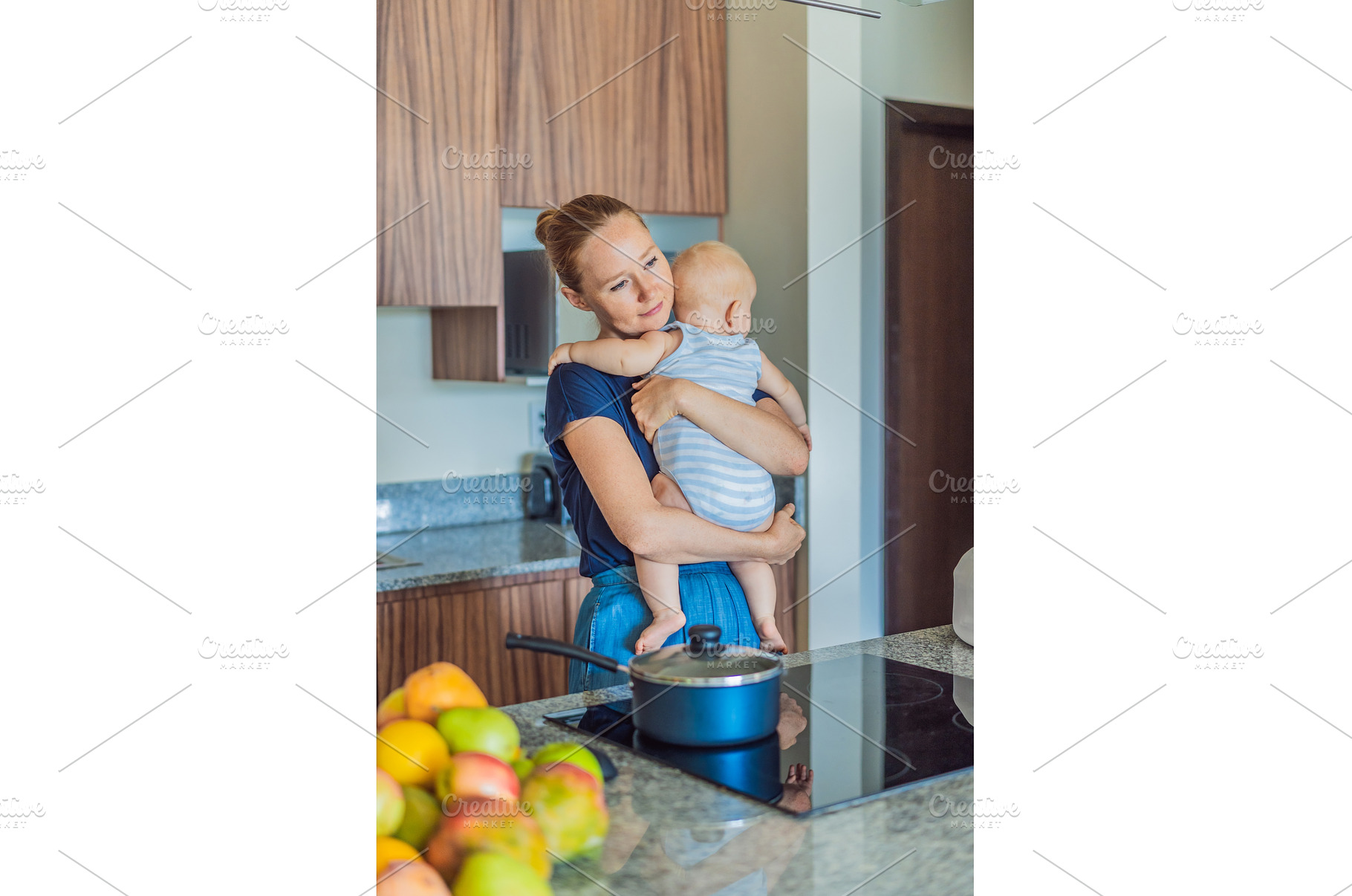 Mother holding baby while cooking, a Food & Drink Photo by Elizaveta Galitskaya