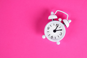 White alarm clock pink background. S