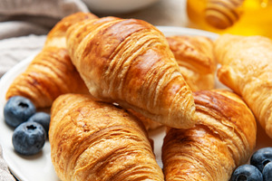 Freshly baked croissants with blueberries and honey for breakfas, a Food & Drink Photo by Olena Rudo