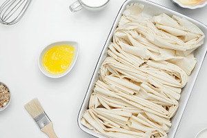 Filo dough in a baking dish next to Crinkle Cake butter for greasing, a Photo by matucha