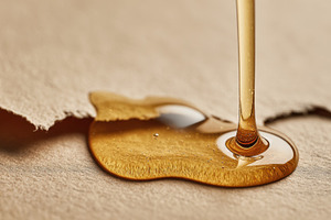 Honey dripping on brown paper, a Photo by Beautiful things