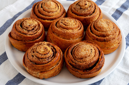 Homemade Cinnamon Roll Pastry on a white wooden background, side, a Food & Drink Photo by LiudmylaChuhunova