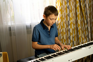 Boy playing digital piano, a Person Photo by Elena Vagengeim