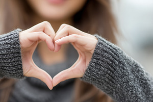 Woman in a cozy sweater forms heart, a Person Photo by MistyDay