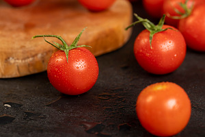 wet small red tomatoes during cooking, red round cherry