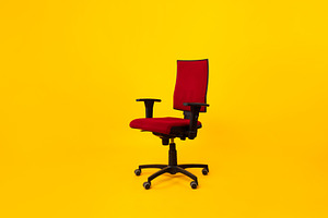 Empty Adjustable Ergonomic Office Chair With Armrests Over Yellow Background, a Photo by Prostock-Studio