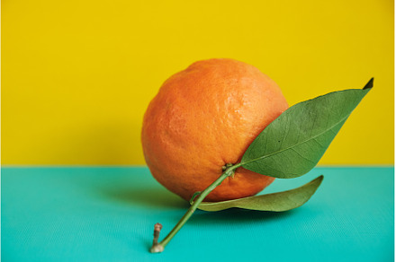 one tangerine with leaf on a yellow, a Food & Drink Photo by Rohan Photography