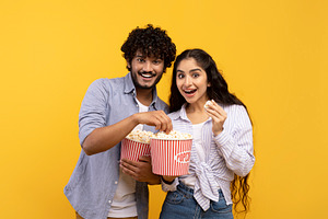 Amazing entertainment, leisure time together. Surprised indian guy and lady eat, a Photo by Prostock-Studio
