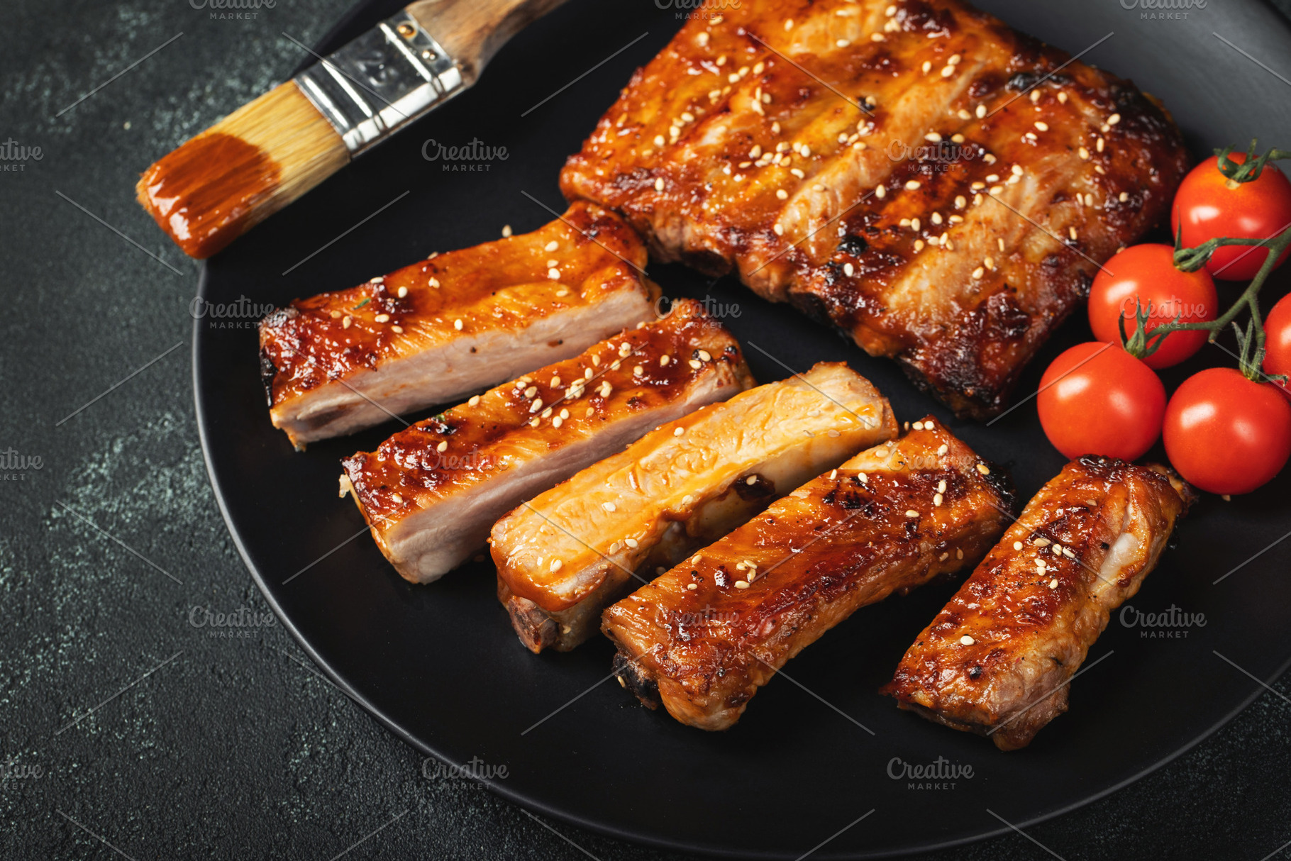 Hot grilled spare ribs from a summer BBQ served on a plate with sauce. Top view, a Food & Drink Photo by Budarinphoto