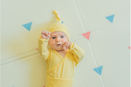 Adorable baby in a yellow hat lying, a Person Photo by Elizaveta Galitskaya