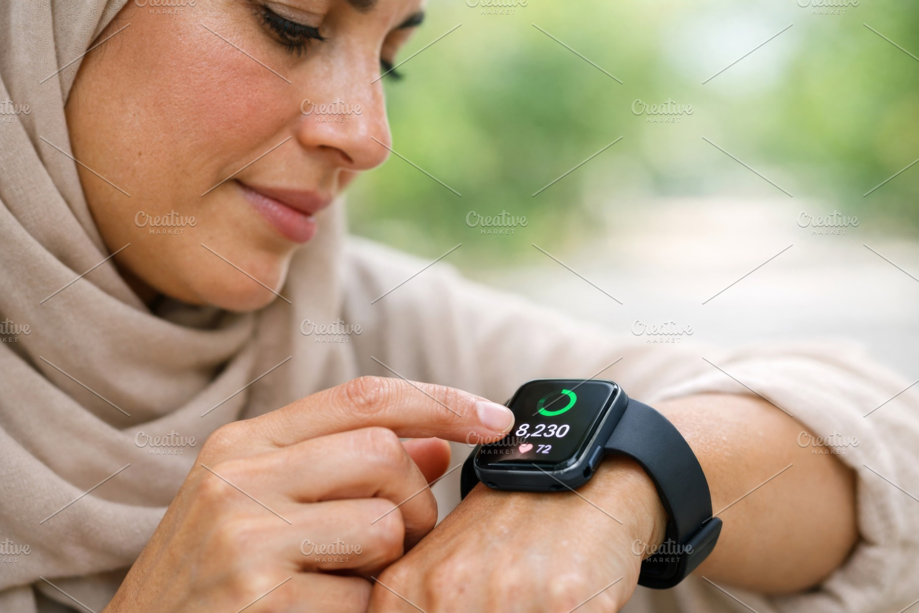 Woman checking fitness tracker durin, a Photo by Dvoevnore photos