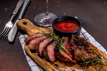 Grilled meat steak on dark table, a Food & Drink Photo by Rimma