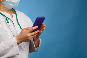 A medical worker in a mask and white coat holding a stethoscope,, a Person Photo by ndanko