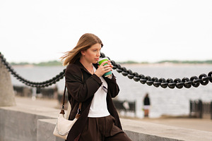 Young woman holding coffee cup, a Person Photo by Elena Vagengeim