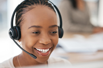 Call center, customer support and face of black woman working, smiling and on client call in office. Customer service, crm and female agent at work talking, consulting and helping customer online, a Photo by Peopleimages.com
