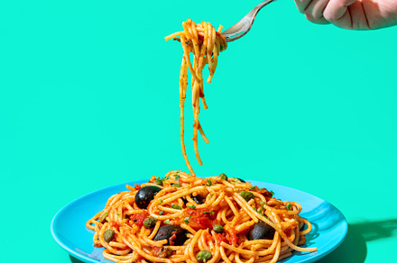 Pasta puttanesca plate minimalist on a green background. Eating, a Food & Drink Photo by YesPhotographers