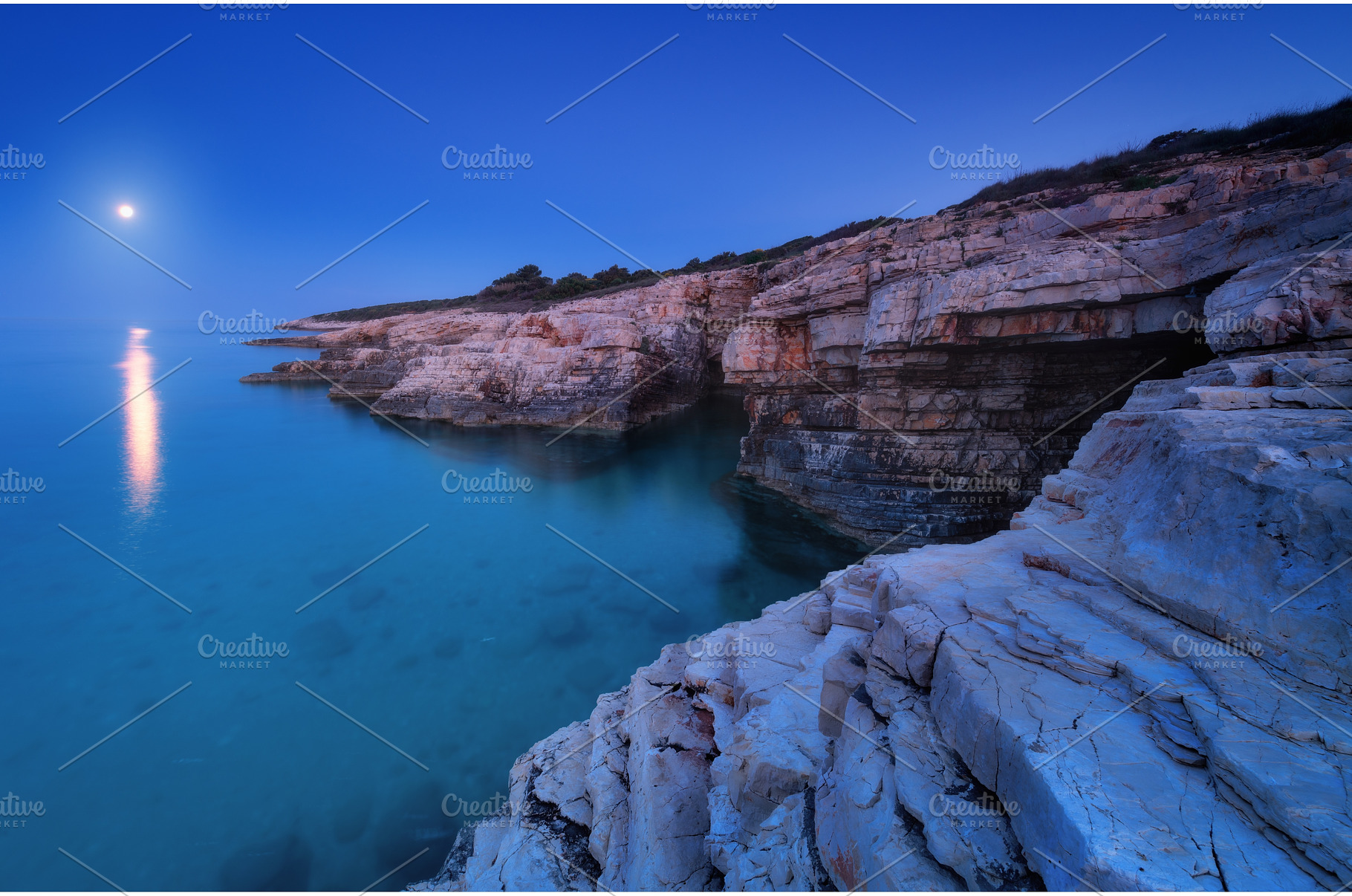 Rocky sea coast and full moon at, a Nature Photo by den-belitsky