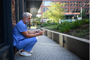 Healthcare worker outside hospital, a Health & Medical Photo by HalfPoint