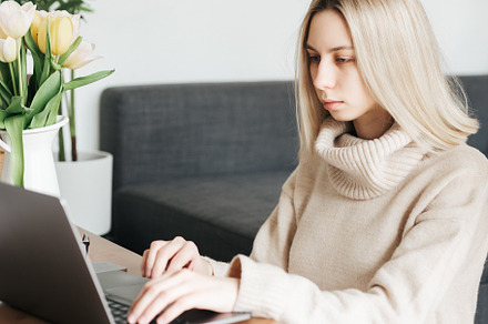 Young woman working on laptop in  home, a Person Photo by Olena Rudo