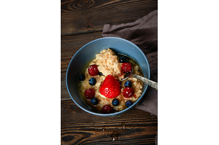 Oatmeal with berries on a wooden, a Food & Drink Photo by sabyna75