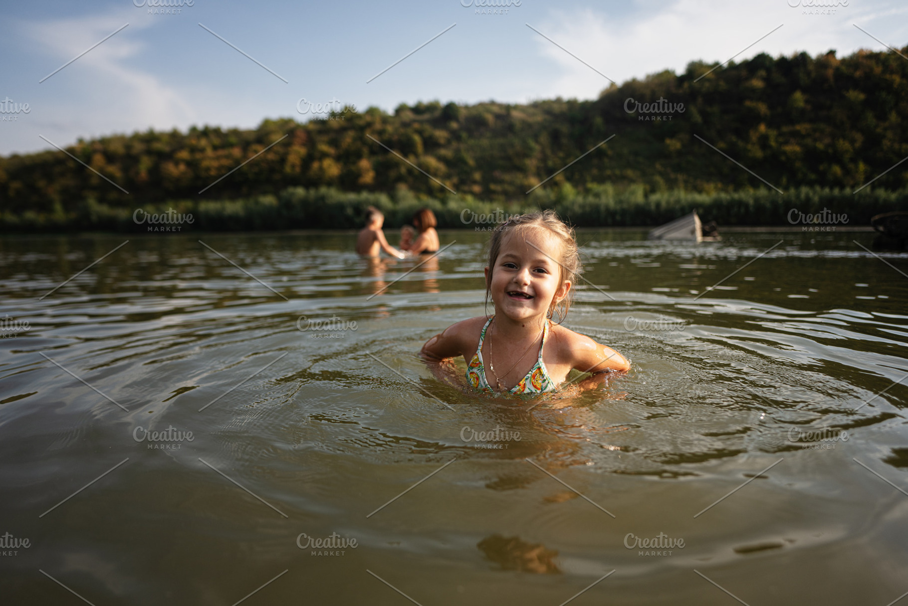 Joyful child swimming in serene river on a sunny day, a Person Photo by AS photostudio