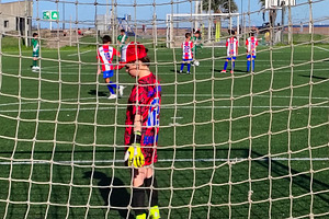 Children playing soccer behind goal net, a Sports & Recreation Photo by DanFLCreativo