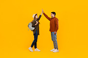 Happy Tourists Couple Giving High Five Standing Over Yellow Background, a Photo by Prostock-Studio (Thumbnail 1 of 2)