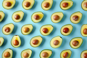 Pattern of fresh avocado pieces on blue background, a Food & Drink Photo by AlyaAnd