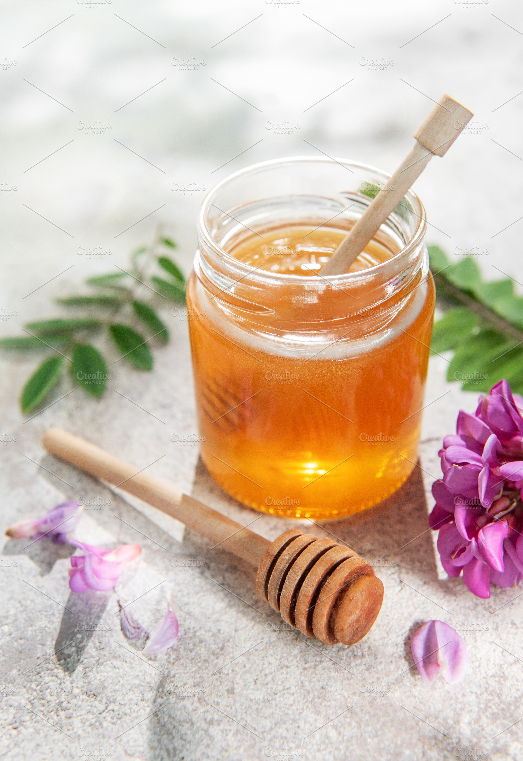 Acacia honey jar on concrete with dipper and flowers, a Food & Drink Photo by Olena Rudo