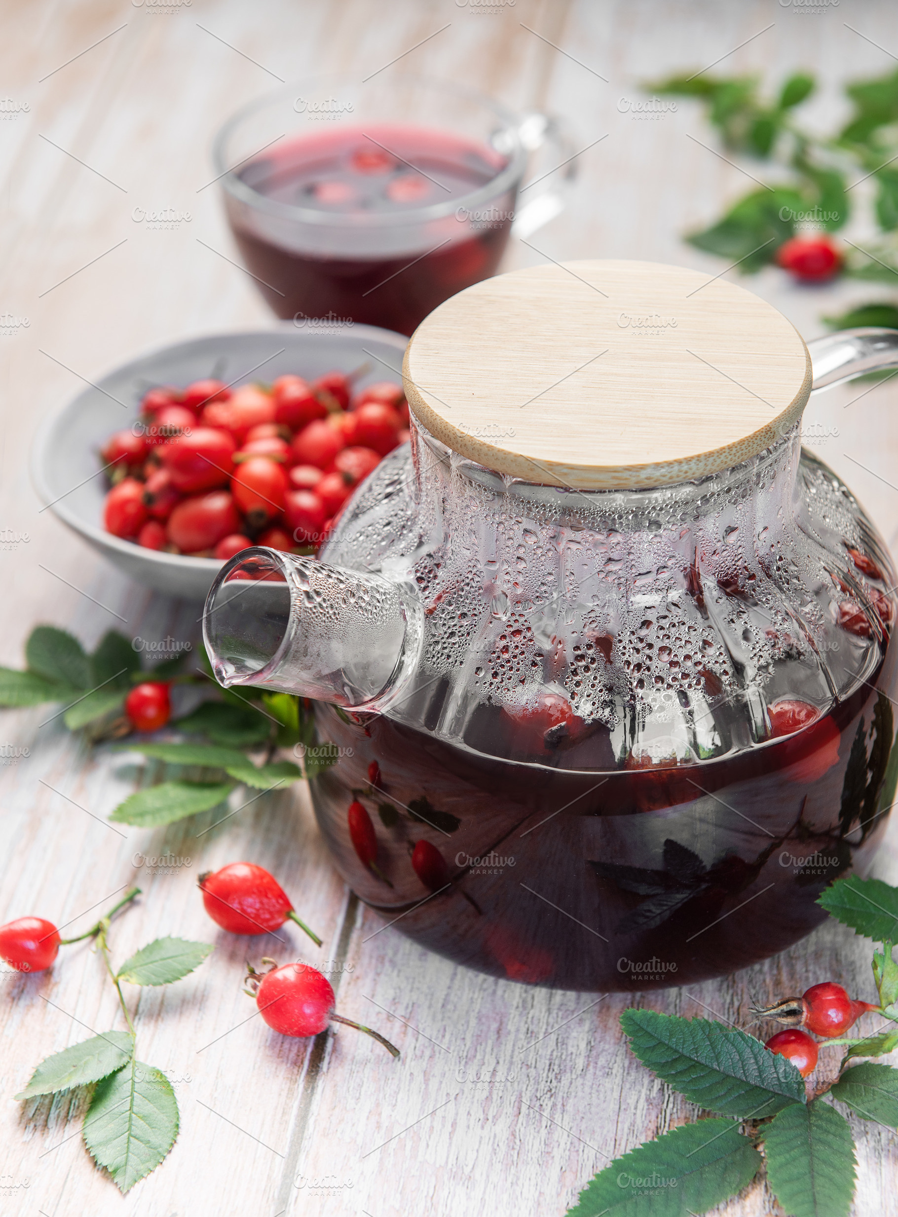 Steaming rosehip tea brewing in glass teapot with fresh rose hip, a Food & Drink Photo by Olena Rudo