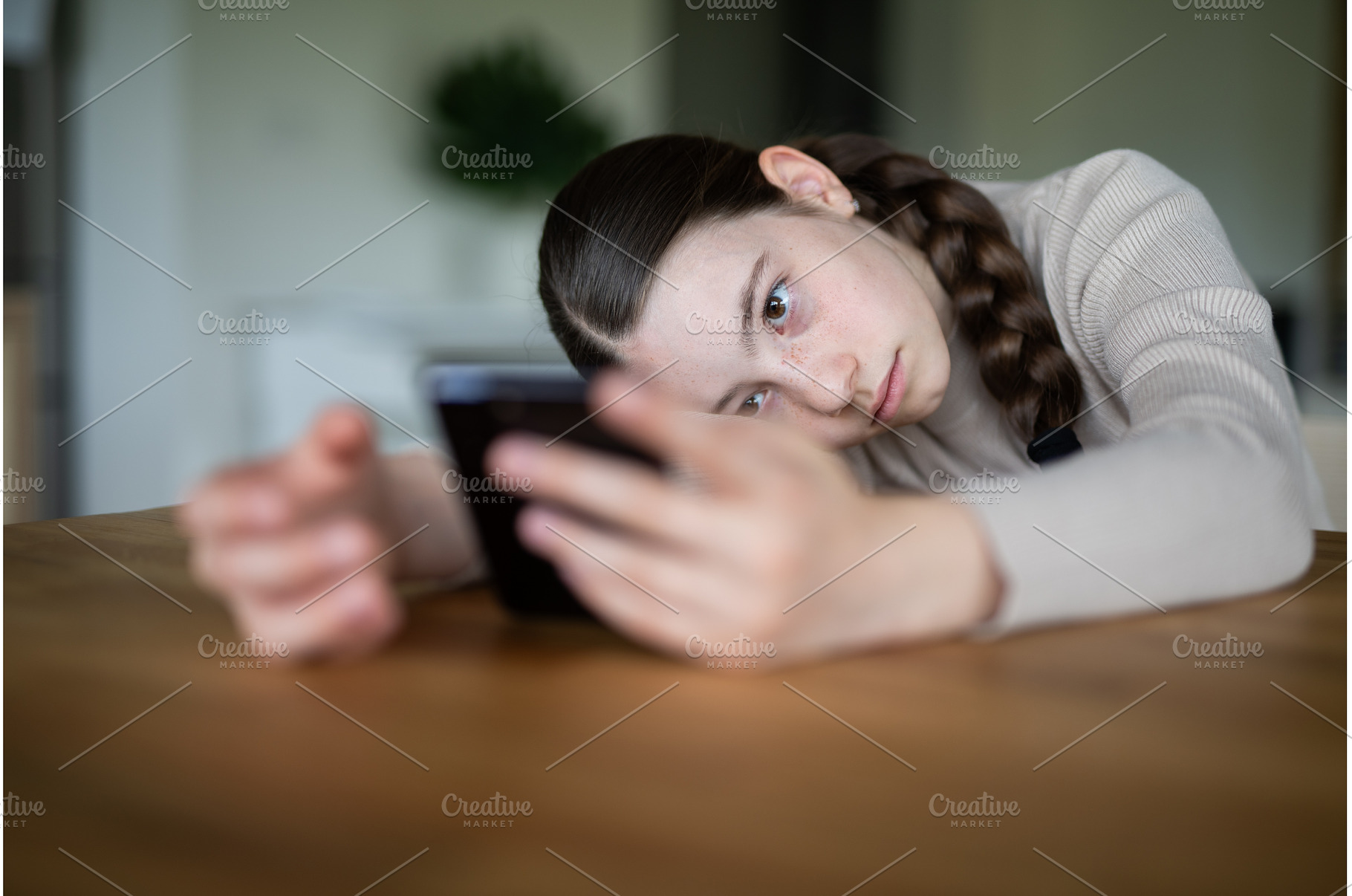 Teen girl looking at phone with, a Person Photo by HalfPoint