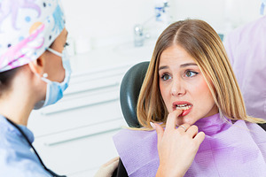 Worried patient touching teeth at the dental clinic, a Health & Medical Photo by Antonio Gravante Market