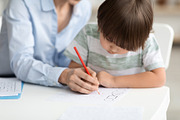 Early development training. Concentrated little boy pupil painting with teacher, a Photo by Prostock-Studio (Thumbnail 1 of 2)