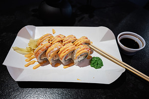 Delicious sushi roll with sauce served on a paper tray with chopsticks, a Photo by AS photostudio