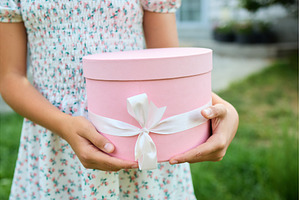 Young girl holds gift box in garden
