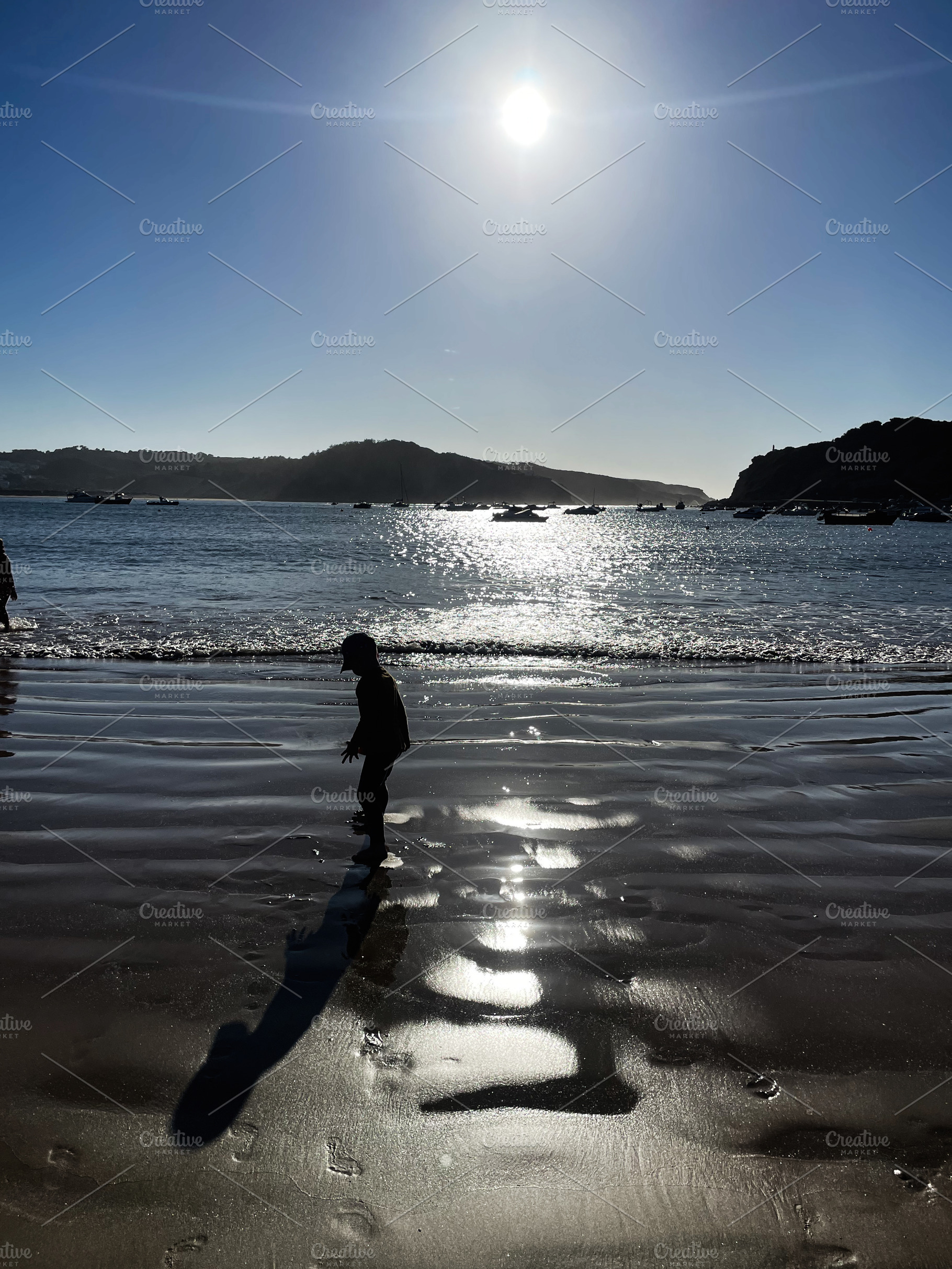 Child Playing in Reflected Sunset on a Beach in Cascais, Portugal, a Photo by AS photostudio