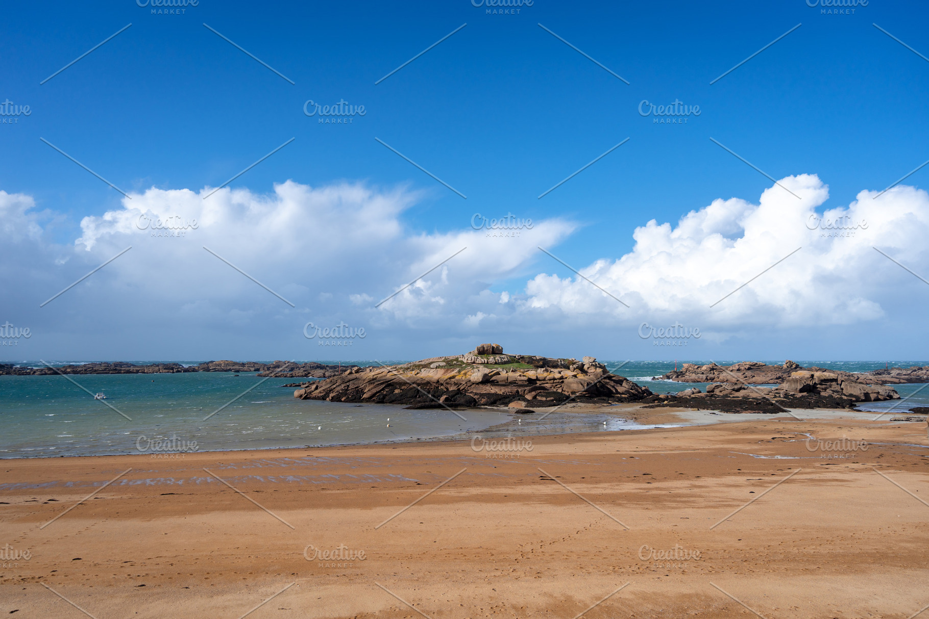 Rocky tidal island under bright skies in Tregastel, Brittany, Fr, a Nature Photo by GoodGoods