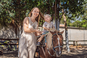 Happy mother shares the joy of pony, a Person Photo by Elizaveta Galitskaya