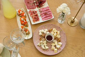 Top view of diverse appetizers including cheese platter, meat cuts and bruschet, a Food & Drink Photo by Rohan Photography