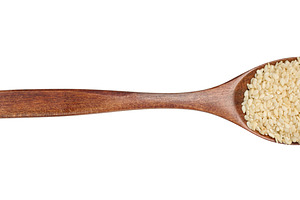 Sesame seeds in a brown wooden spoon on isolated background, top, a Food & Drink Photo by ndanko