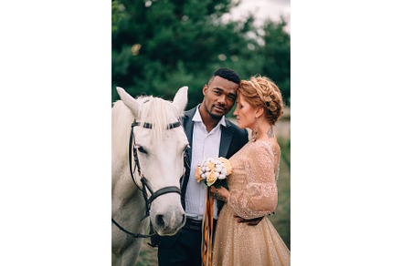 Newlyweds are standing near a white stock photo containing couple and lovers, a Person Photo by Maksym Zaitsev