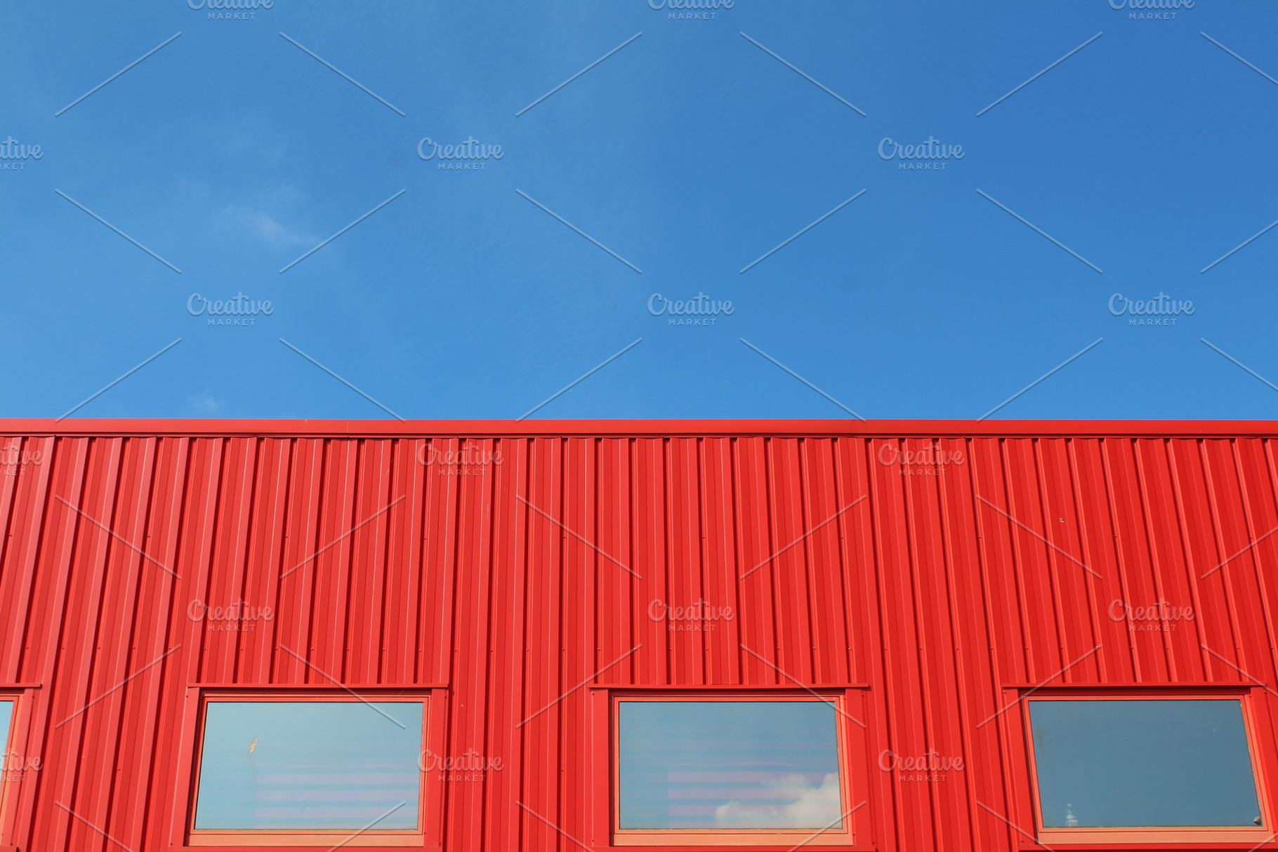 Red building with a blue sky stock photo containing urban and building, an Architecture Photo by The Pixels Factory