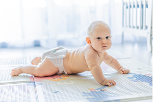 Baby lying on play mat learning to