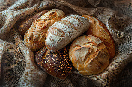 Different kinds of baked bread on burlap, a Food & Drink Photo by AlyaAnd