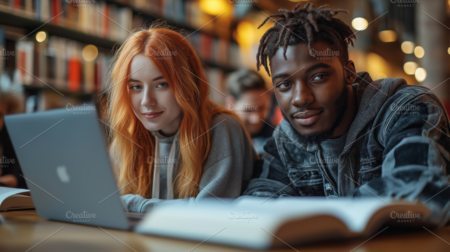 A young Caucasian woman and a young Black man smile at the camera while studyin, a Person Photo by ImageMir