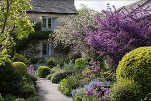 Quaint English cottage surrounded by a vibrant spring garden fea, a Photo by Studio ANNA