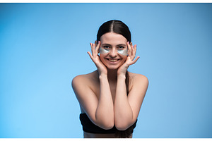 Woman with eye patches smiling for, a Health & Medical Photo by volodymyrshtun13795