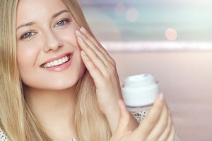 Young woman applying face cream, smiling, caring for skin, hydra, a Person Photo by Studio ANNA